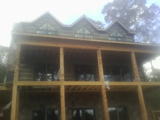 Dormers and porch framing on a large log home under construction — Roof Coating work by our crew in Rossville